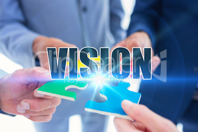 Vision against business colleagues holding piece of puzzle