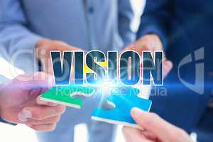 Vision against business colleagues holding piece of puzzle