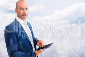 Composite image of businessman using a tablet and smiling at the