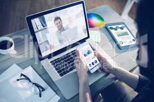 Composite image of handsome man working at his desk on laptop sm