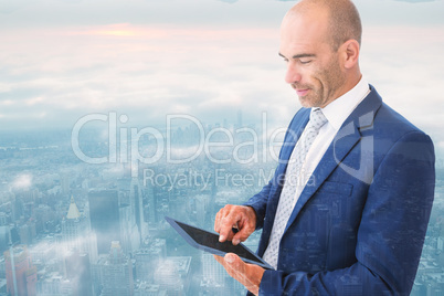 Composite image of businessman using a tablet