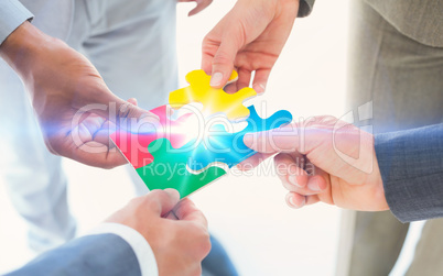 Business colleagues holding piece of puzzle