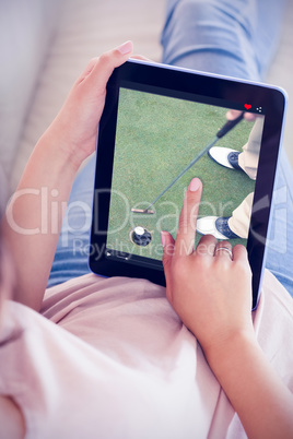 Composite image of girl using her tablet on the couch