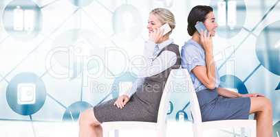 Composite image of businesswomen using smartphones while sitting