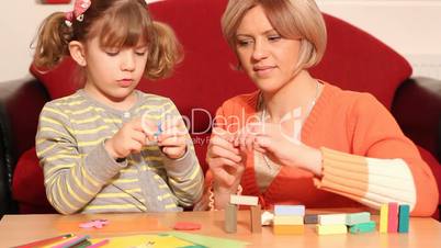 mother and daughter play with plasticine