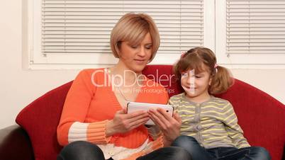 mother and daughter play with tablet