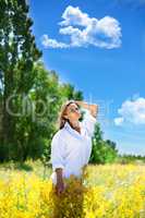 The girl holds a bouquet of wild flowers in hand.