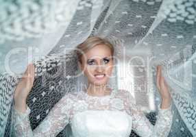 Blond bride with blue eyes in a white dress