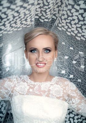 Blond bride with blue eyes in a white dress