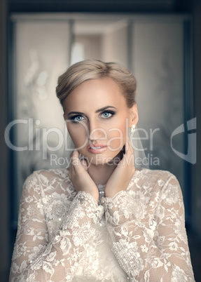 Blond bride with blue eyes in a white dress
