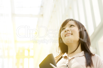 Young Asian female executive looking up