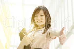 Young Asian female executive thumb up