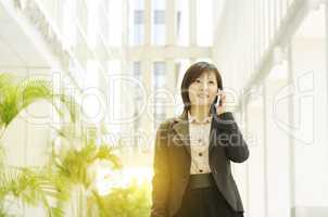 Young Asian business woman talking on phone