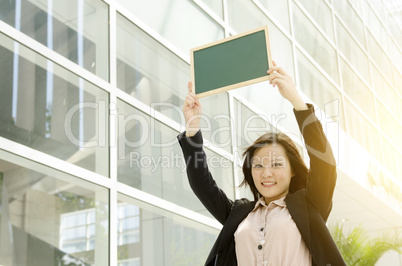 Young Asian business woman showing blank chalkboard