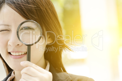 Asian female searching with magnifier