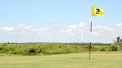 golf field with yellow flag number two