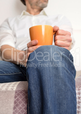 Man on a sofa with a pot of coffee