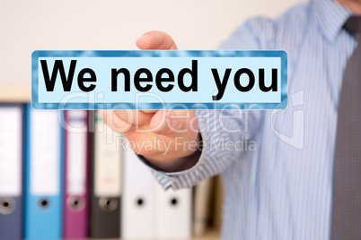 Businessman holding sign with inscription, We need you