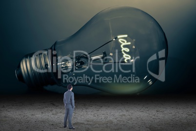 Businessman looking at giant light bulb