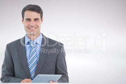 Smiling businessman holding tablet