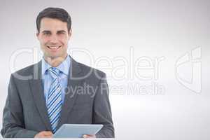 Smiling businessman holding tablet