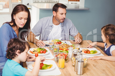 Family having lunch while sitting at dining table