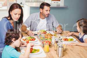 Family having lunch while sitting at dining table