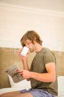Handsome man reading the news and drinking coffee