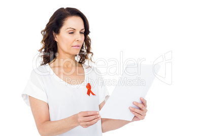 Woman wearing red aids awareness ribbon reading test result
