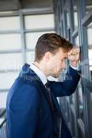 Tired businessman leaning on door