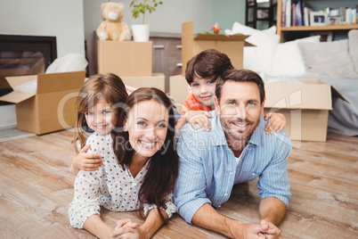 Portrait of happy family lying on hardwood floor