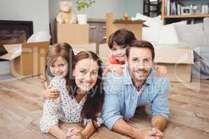 Portrait of happy family lying on hardwood floor