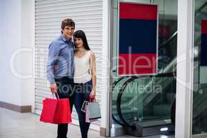 Couple standing near escalator in shopping mall