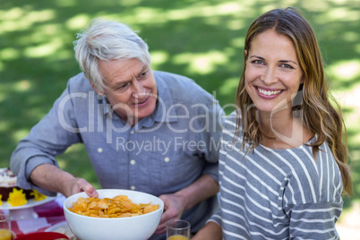 Senior man offering crisps to young woman