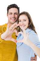 Happy couple showing a heart shape with their fingers