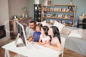 Happy family using computer at home