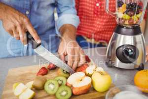 Midsection of couple preparing fruit juice