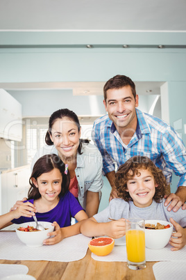 Cheerful man and woman with children having breakfast