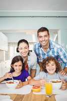 Cheerful man and woman with children having breakfast
