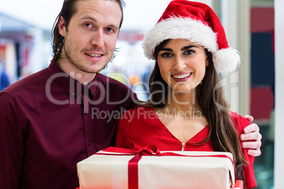 Portrait of a couple in Christmas attire standing with Christmas