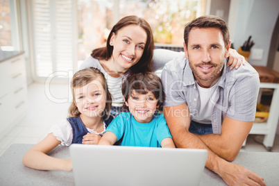 Portrait of happy family with laptop