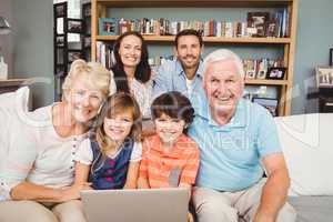 Portrait of smiling family with laptop