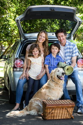 Smiling family sitting in the luggage space