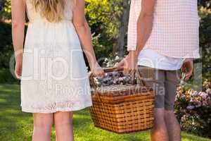 Rear view of a couple holding a picnic basket together