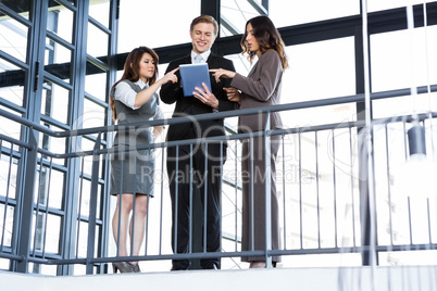 Businessman and businesswomen looking at digital tablet