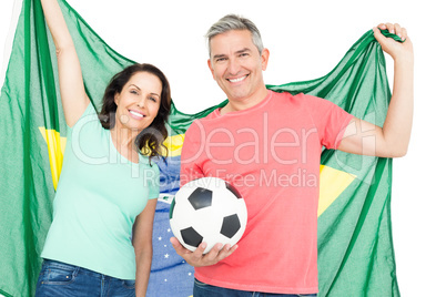 Happy couple fan of soccer holding Brazil flag