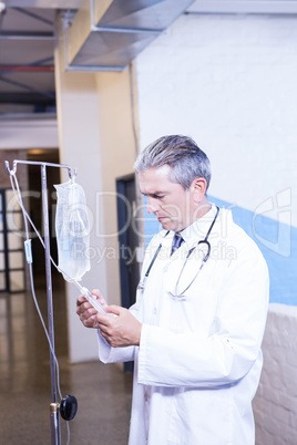 Male doctor checking a saline drip