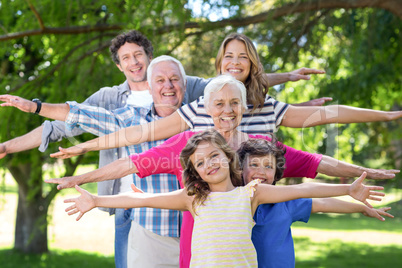 Smiling family standing with arms stretched out