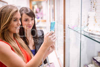 Two women taking a photo of shop display