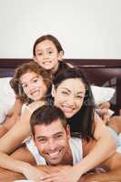 Portrait of happy family lying on bed